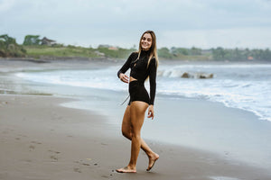 Slim woman wearing high cut shorts and long sleeve black yoga top.
